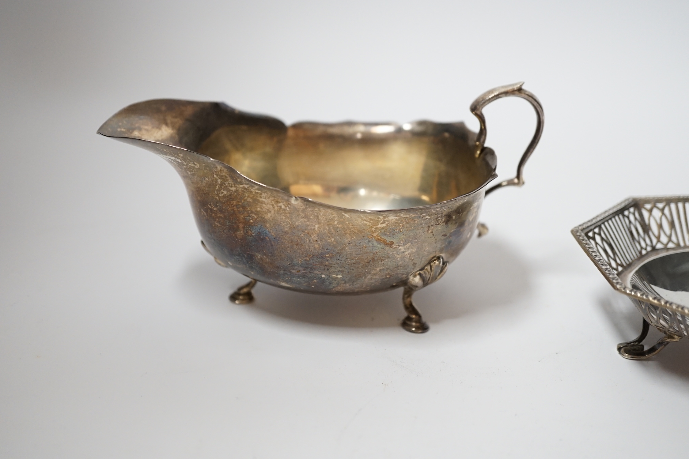 A George V silver sauce boat, Adie Bros. Birmingham, 1925, a pair of George V pierced silver bonbon dishes, Mappin & Webb, Birmingham 1930, 10.2cm and a pair of Georgian silver sugar tongs.